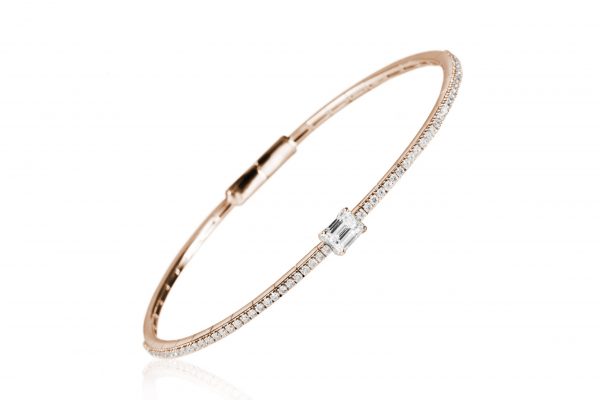 18ct gold White Diamond flexible core bangle with one central Emerald Cut Diamond